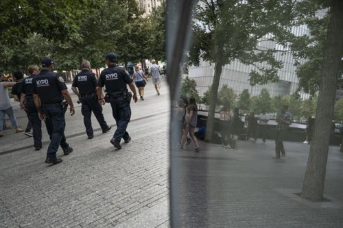 NYPD officer Michael Dougherty, a 25-year veteran, patrols with his colleagues at the National September 11 Memorial & Museum where names of his deceased colleagues and friends are displayed, Monday, Aug. 16, 2021, in New York. 