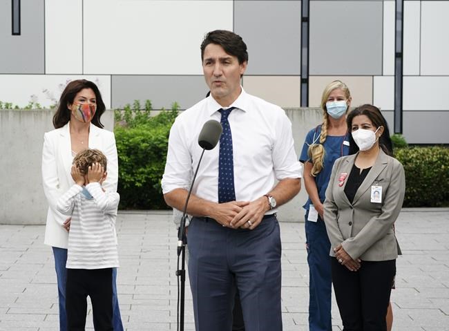 Liberal Leader Justin Trudeau answers questions as his son Hadrien and wife Sophie Grégoire Trudeau, left, and BC Nurses, right, stand to his side at a campaign stop in Vancouver, B.C., on Monday, Sept. 13, 2021. THE CANADIAN PRESS/Sean Kilpatrick
