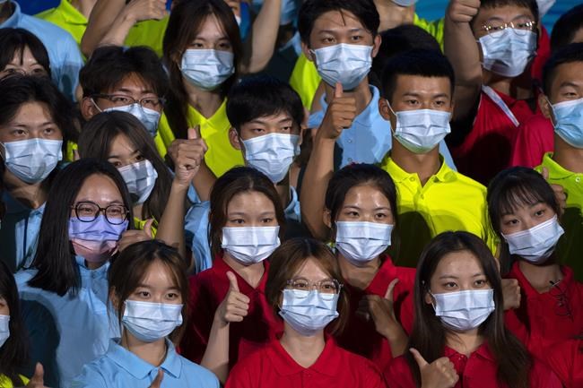Participants wearing face masks pose for a group photo after a launch ceremony to reveal the motto for the 2022 Beijing Winter Olympics and Paralympics in Beijing, Friday, Sept. 17, 2021. Organizers on Friday announced