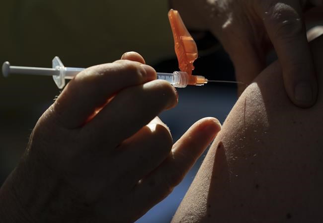 A dose of the Pfizer-BioNTech COVID-19 vaccine is given to a recipient at a vaccination site in Vancouver Thursday, March 11, 2021. Prime Minister Justin Trudeau will make good today on his election promise to require all federal employees to be fully vaccinated against COVID-19. THE CANADIAN PRESS/Jonathan Hayward