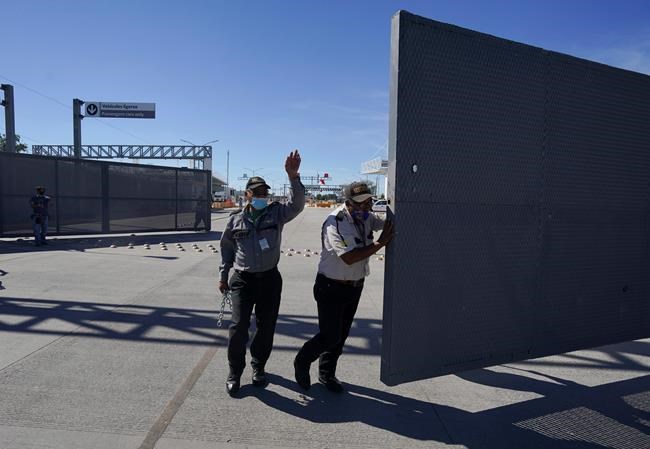 Mexican security officers open the main gate of the international border bridge that connects Del Rio, Texas and Ciudad Acuna, Mexico, after its partial reopening Saturday, Sept. 25, 2021. A new trilateral poll suggests U.S. residents are far more worried about reopening the land border with Mexico than they are about letting Canadians drive into the country.THE CANADIAN PRESS/AP/Fernando Llano