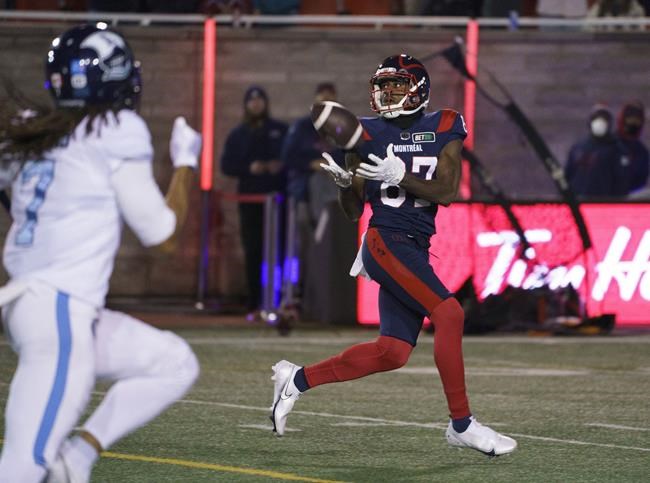 Montreal Alouettes wide receiver Eugene Lewis catches the ball in front of Toronto Argonauts defensive back Jalen Collins and runs in for a touchdown during second quarter CFL football action in Montreal on Friday, October 22, 2021. THE CANADIAN PRESS/Paul Chiasson