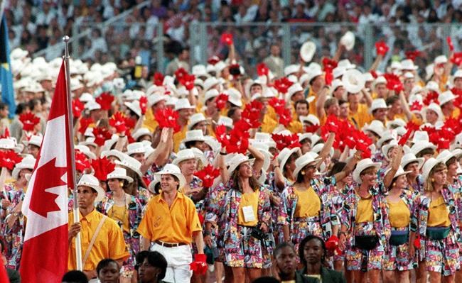 Canadian athletes, lead by flag bearer decathlete Mike Smith, parade onto the field at Olympic stadium in Barcelona on July 25, 1992.