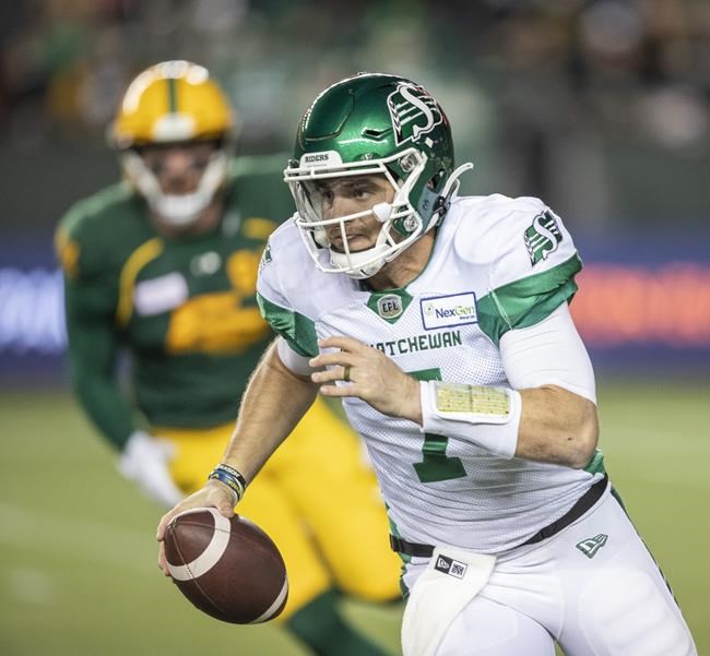 Saskatchewan Roughriders quarterback Cody Fajardo (7) runs the ball under pressure from Edmonton Elks' Chris Nelson (92) during first half CFL action in Edmonton on Friday, November 5, 2021. THE CANADIAN PRESS/Amber Bracken