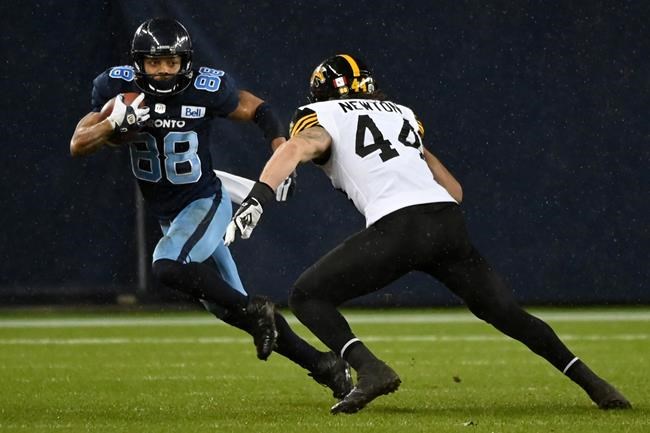 Toronto Argonauts wide receiver Chandler Worthy (88) runs the ball around Hamilton Tiger-Cats linebacker Curtis Newton during first half CFL football action in Toronto Friday, Nov. 12, 2021. THE CANADIAN PRESS/Jon Blacker