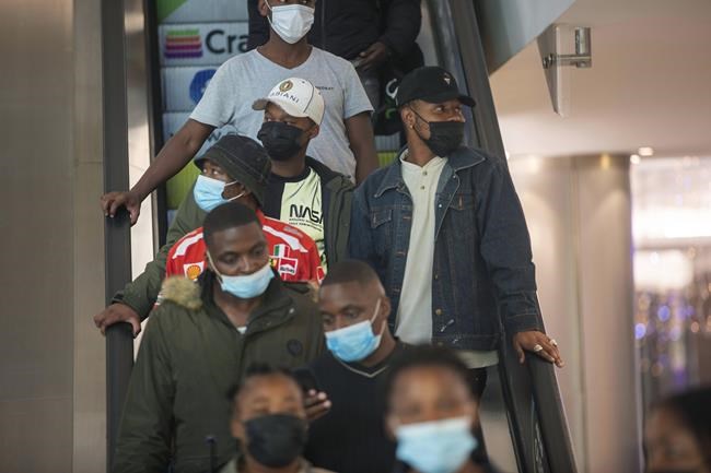 People wearing masks on an escalator at a shopping mall, in Johannesburg, South Africa, Friday Nov. 26, 2021. Advisers to the World Health Organization are holding a special session Friday to flesh out information about a worrying new variant of the coronavirus that has emerged in South Africa, though its impact on COVID-19 vaccines may not be known for weeks. (AP Photo/Denis Farrell)