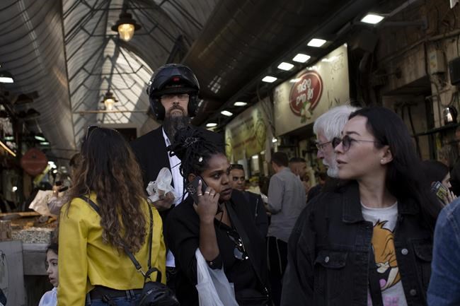 People shop at the Mahane Yehuda market in Jerusalem ahead of Shabbat and the Jewish holiday of Hanukkah, Friday, Nov. 26, 2021. Israel's prime minister says it is