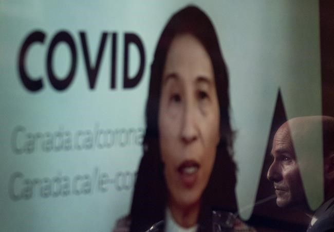 Health Minister Jean-Yves Duclos is reflected on a television screen as Dr. Theresa Tam, Canada's chief public health officer, appears at a news conference by video conference, Friday, November 26, 2021 in Ottawa. THE CANADIAN PRESS/Adrian Wyld