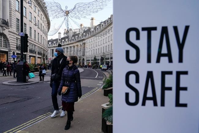 People wear face masks as they walk, in Regent Street, in London, Sunday, Nov. 28, 2021. Britain's Prime Minister Boris Johnson said it was necessary to take