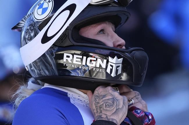 Kaillie Humphries of the United States watches the leaderboard after the women's two-women bobsleigh World Cup race in Igls, near Innsbruck, Austria, Sunday, Nov. 21, 2021. (AP Photo/Matthias Schrader)