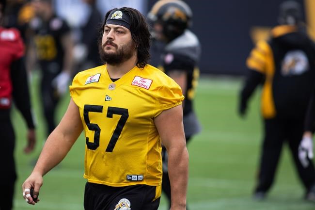 Hamilton Tiger-Cats offensive lineman Brandon Revenberg (57) takes part in a practice at Tim Hortons Field during the CFL's Grey Cup week in Hamilton, Ontario on Friday, December 10, 2021. The Hamilton Tiger-Cats will play the Winnipeg Blue Bombers in the 108th Grey Cup on Sunday. THE CANADIAN PRESS/Nick Iwanyshyn