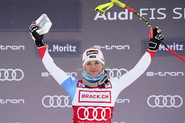 Switzerland's Lara Gut-Behrami, first placed, celebrates on the podium of an alpine ski, women's World Cup super-G in St. Moritz, Switzerland, Saturday, Dec. 11, 2021. (AP Photo/Pier Marco Tacca)