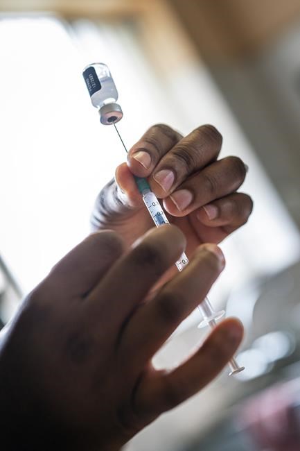 A nurse fills a syringe with COVID-19 vaccine at Soweto's Baragwanath hospital, South Africa, Monday Dec. 13, 2021. South Africa's 7-day rolling average of daily new COVID-19 cases has risen over the past two weeks from 7.60 new cases per 100,000 people on Nov. 28 to 32.71 new cases per 100,000 people on Dec. 12, according to Johns Hopkins University. In general, the new omicron cases have resulted in milder cases, with fewer hospitalizations and less severe cases requiring oxygen or intensive care. (AP Photo/Jerome Delay)