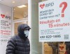 A man walks by a COVID-19 rapid testing business in Montreal, Saturday, Dec. 4, 2021. THE CANADIAN PRESS/Graham Hughes