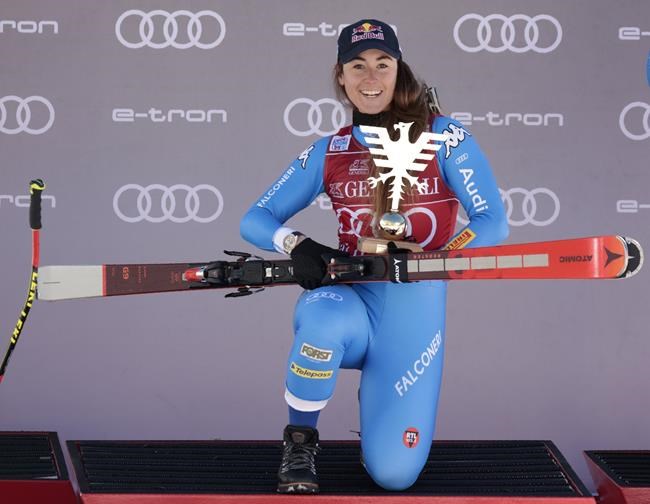 Italy's Sofia Goggia celebrates on the podium after winning an alpine ski, women's World Cup super-G race in Val D'Isere, France, Sunday, Dec. 19, 2021. (AP Photo/Giovanni Pizzato)