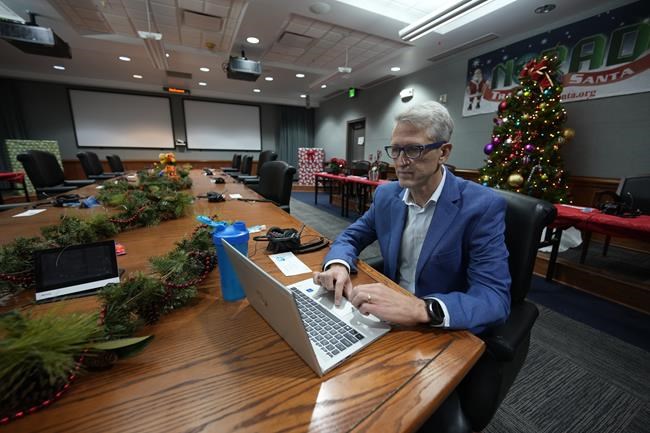Preston Schlachter, public affair officer for NORAD, works on a laptop computer in one of the conference rooms that have banks of telephones set up for volunteers to field calls in the NORAD Tracks Santa Operations Center on Peterson Air Force Base Wednesday, Dec. 22, 2021, in Colorado Springs, Colo. The tracking operation will be open for 20 hours on Christmas Eve day to help keep an eye on the whereabouts of Santa Claus. (AP Photo/David Zalubowski)
