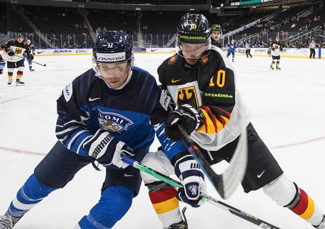 Finland's Joel Määttä (32) and Germany's Danjo Leonhardt (10) battle for the puck during third period IIHF World Junior Hockey Championship action in Edmonton, Sunday, Dec. 26, 2021. THE CANADIAN PRESS/Jason Franson