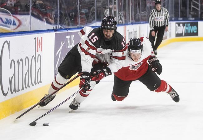Canada's Shane Wright (15) and Austria's Tobias Sablattnig (12) battle for the puck during second period IIHF World Junior Hockey Championship action in Edmonton on Tuesday, December 28, 2021. THE CANADIAN PRESS/Jason Franson