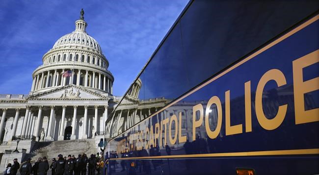 A large group of police arrive on a bus at the Capitol, Thursday, Jan. 6, 2022, in Washington. President Joe Biden and members of Congress are solemnly marking the first anniversary of the Jan. 6 U.S. Capitol insurrection. Lawmakers are holding events Thursday to reflect on the violent attack by supporters of then-President Donald Trump. The ceremonies will be widely attended by Democrats, but almost every Republican on Capitol Hill will be absent. (AP Photo/Julio Cortez)