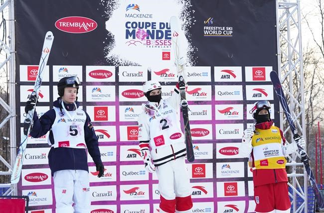 Canada's Mikael Kingsbury, middle, celebrates his win on the podium along with second place Walter Wallberg of Sweden, left, and third place Ikuma Horishima, right, in the men's freestyle ski world cup moguls at Mont Tremblant, Que., on Friday, Jan. 7, 2022. This is Kingsbury's 69th world cup win. THE CANADIAN PRESS/Sean Kilpatrick