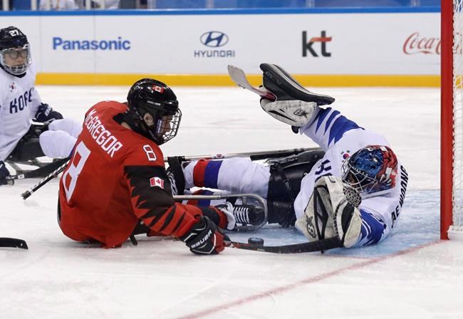 Tyler McGregor of Canada, left, is blocked by South Korea's goalie Lee Jae-woong during a semifinal of the ice hockey game at the 2018 Winter Paralympics in Gangneung, South Korea, Thursday, March 15, 2018. THE CANADIAN PRESS/AP/Lee Jin-man