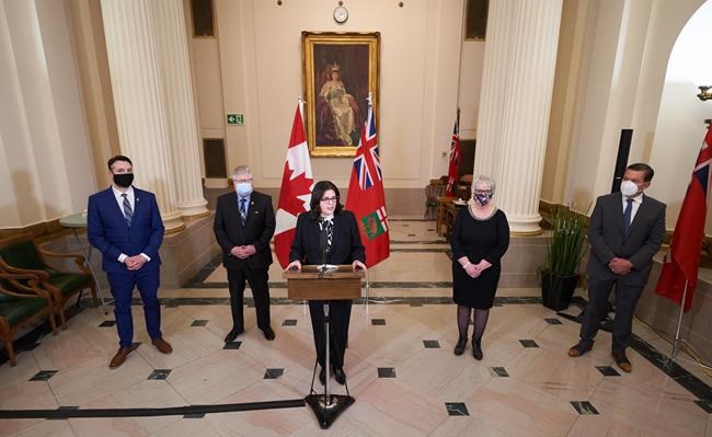 Manitoba Premier Heather Stefanson, center, speaks to the media at a news conference following a swearing-in ceremony for her new cabinet, alongside ministers Andrew Smith, left; Scott Johnston, second from left; Eileen Clarke, second from right; and Doyle Piwniuk, right, at the Manitoba Legislative Building in Winnipeg on Tuesday Jan. 18, 2022. THE CANADIAN PRESS/David Lipnowski