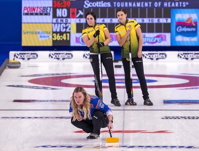 Wild Card 2 team skip Chelsea Carey watches a rock as Northern Ontario's Ashley Sippala, left, and Sarah Potts look on at the Scotties Tournament of Hearts at Fort William Gardens in Thunder Bay, Ont. on Friday, Jan. 28, 2022. THE CANADIAN PRESS/Andrew Vaughan