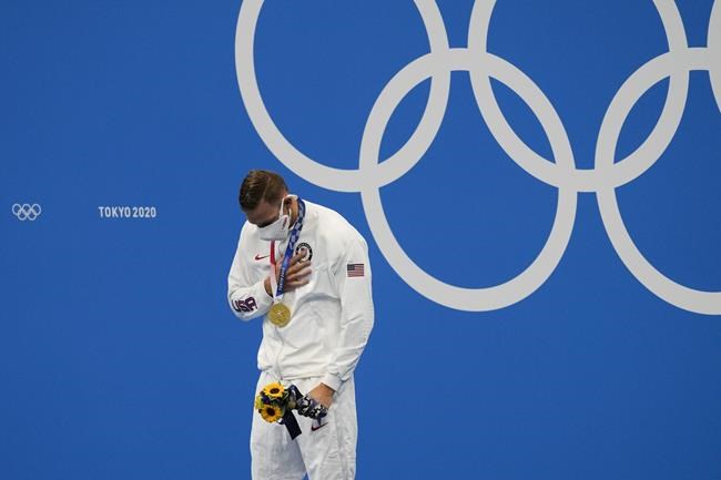 FILE - Caeleb Dressel, of the United States, celebrates his gold medal in the men's 4x100-meter medley relay final at the 2020 Summer Olympics, Aug. 1, 2021, in Tokyo. Two-time Alpine skiing gold medalist Mikaela Shiffrin has been thinking a lot about the stress and pressure that gymnast Simone Biles and swimmer Dressel discussed during last year's Tokyo Olympics. And Shiffrin knows that she will face similar burdens when her races at the Beijing Winter Games. (AP Photo/Jae C. Hong, File)
