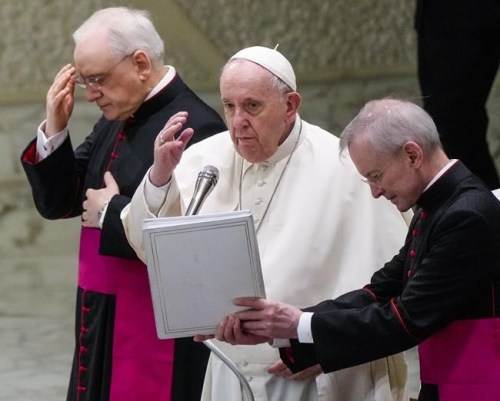 Pope Francis, center, flanked by Monsignor Leonardo Sapienza, left, and Monsignor Guido Marini, blesses the attendance at the end his weekly general audience in the Paul VI Hall at the Vatican, Wednesday, Feb. 02, 2022. (AP Photo/Gregorio Borgia)