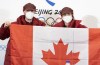 Speedskater Charles Hamelin, left, and hockey player Marie-Philip Poulin hold up the Canadian flag after being named as flag bearers at a news conference Wednesday, February 2, 2022 at the 2022 Winter Olympics in Beijing. THE CANADIAN PRESS/Ryan Remiorz