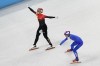 Wu Dajing, left, of China, celebrates after crossing the finish line ahead of Pietro Sighel, of Italy, to earn a gold medal for his team in the mixed relay short track speedskating competition at the 2022 Winter Olympics, Saturday, Feb. 5, 2022, in Beijing. (AP Photo/Jeff Roberson)