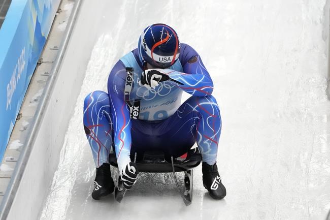 Jonathan Gustafson, of the United States, looks down after finishing the luge men's single round 3 at the 2022 Winter Olympics, Sunday, Feb. 6, 2022, in the Yanqing district of Beijing. (AP Photo/Mark Schiefelbein)