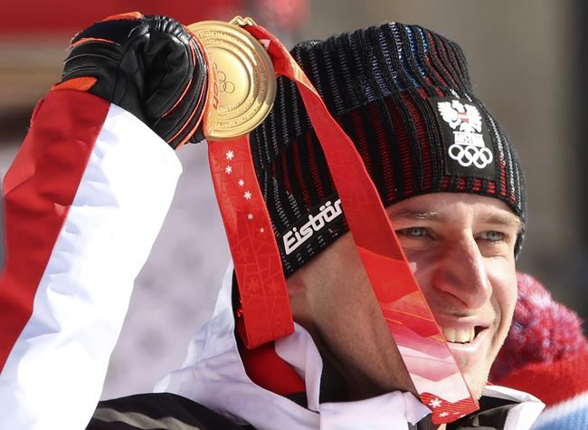 Matthias Mayer of Austria celebrates with his gold medal during the medal ceremony for the men's super-G at the 2022 Winter Olympics, Tuesday, Feb. 8, 2022, in the Yanqing district of Beijing. (AP Photo/Alessandro Trovati)