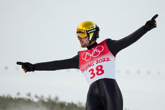 Johannes Rydzek, of Germany, celebrates after his jump during the ski jump portion of the individual Gundersen normal hill event at the 2022 Winter Olympics, Wednesday, Feb. 9, 2022, in Zhangjiakou, China. (AP Photo/Matthias Schrader)