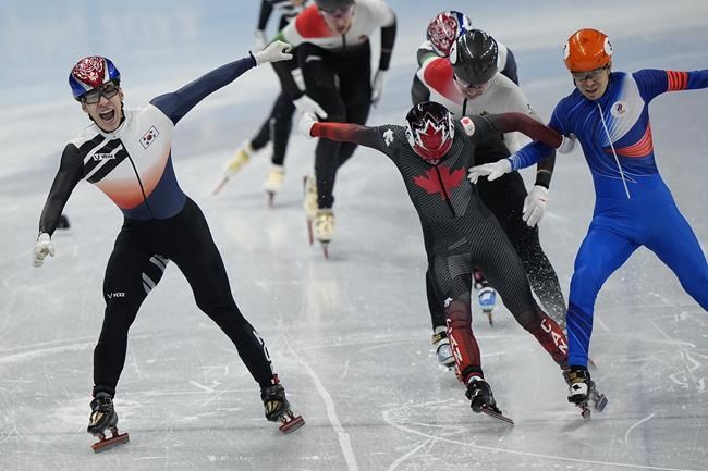 Hwang Dae-heon, left, of South Korea, reacts after winning his men's 1500-meters final during the short track speedskating competition at the 2022 Winter Olympics, Wednesday, Feb. 9, 2022, in Beijing.(AP Photo/David J. Phillip)
