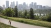 A pedestrian walks on a trail with the Calgary skyline in the background on Thursday, July 15, 2021.Once Canada's boomtown, the latest census from Statistics Canada suggests Wild Rose Country is becoming just another Canadian province. THE CANADIAN PRESS/Jeff McIntosh