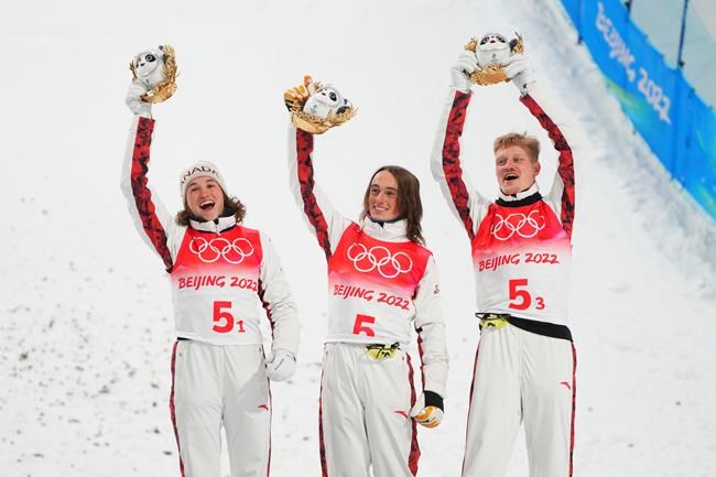 Canada's (left to right) Marion Thenault, Miha Fontaine and Lewis Irving celebrate on the podium after winning the bronze medal in the freestyle skiing mixed team aerials event at the Beijing Winter Olympic Games, in Zhangjiakou, China, Thursday, Feb. 10, 2022. THE CANADIAN PRESS/Sean Kilpatrick