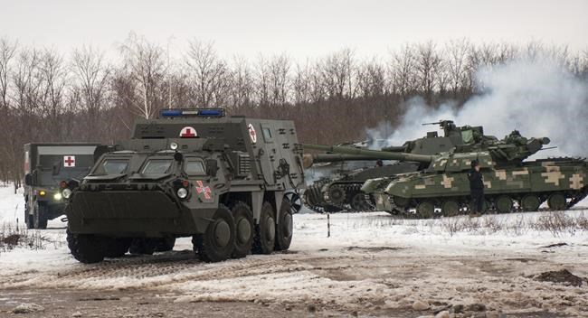 Ukrainian armored vehicles drive during military drills close to Kharkiv, Ukraine, Thursday, Feb. 10, 2022. Britain's envoy to Canada says the two countries are cooperating on a tough new set of sanctions against Russia if it invades Ukraine. (AP Photo/Andrew Marienko)