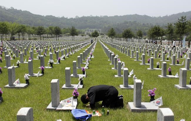 FILE- South Korean Kim Young-kil, 74, bows in front of the gravestone of his brother Kim Young-ki who died during the 1950-1953 Korean War, on the eve of South Korea's Memorial Day at the National Cemetery in Seoul, South Korea Sunday, June 5, 2011. (AP Photo/Lee Jin-man, File)
