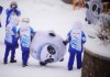Volunteers carry an inflatable of Bing Dwen Dwen, the mascot of the 2022 Winter Olympics, at the sliding center, Sunday, Feb. 13, 2022, in the Yanqing district of Beijing. (AP Photo/Dmitri Lovetsky)