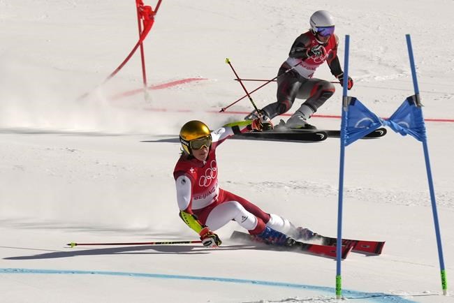 Katharina Liensberger of Austria, front, and Norway's Maria Therese Tviberg race in a semifinal of the mixed team parallel skiing event at the 2022 Winter Olympics, Sunday, Feb. 20, 2022, in the Yanqing district of Beijing. (AP Photo/Luca Bruno)