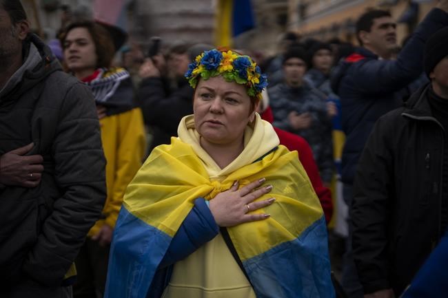 Demonstrators sing the national anthem during a protest in Odessa, Ukraine, Sunday, Feb. 20, 2022.Thousands of people in Odessa marched through the streets of the city in a show of unity on Sunday, marking the date on which, eight years ago, more than a hundred people were killed during Ukraine's Maidan revolution. Waving national flags and placards with slogans such as, 'No Putin, No Cry', people said they had come out to demonstrate against a potential Russian invasion, and said that they were prepared to defend their city if needed. (AP Photo/Emilio Morenatti)