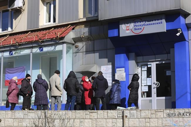 People line up to withdraw money from an ATM in Donetsk, the territory controlled by pro-Russian militants, eastern Ukraine, Monday, Feb. 21, 2022. World leaders are making another diplomatic push in hopes of preventing a Russian invasion of Ukraine, even as heavy shelling continues in Ukraine's east. (AP Photo/Alexei Alexandrov)