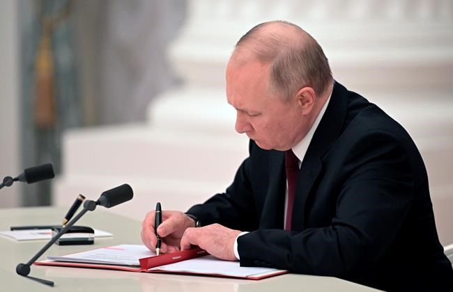 Russian President Vladimir Putin signs a document recognizing the independence of separatist regions in eastern Ukraine in the Kremlin in Moscow, Russia, Monday, Feb. 21, 2022. Russia's Putin has recognized the independence of separatist regions in eastern Ukraine, raising tensions with West. (Alexei Nikolsky, Sputnik, Kremlin Pool Photo via AP)