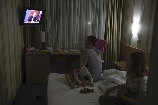 People from the Donetsk and Luhansk regions, the territory controlled by a pro-Russia separatist governments in eastern Ukraine, watch Russian President Vladimir Putin's address at their temporary place in Rostov-on-Don region, Russia, Monday, Feb. 21, 2022. Putin said he would decide later Monday whether to recognize the independence of separatist regions in eastern Ukraine, a move that would ratchet up tensions with the West amid fears that Moscow could launch an invasion of Ukraine imminently. (AP Photo/Denis Kaminev)