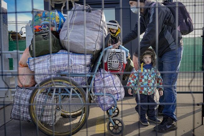 A family crosses from pro-Russian separatists controlled territory to Ukrainian government controlled areas in Stanytsia Luhanska, the only crossing point open daily, in the Luhansk region, eastern Ukraine, Tuesday, Feb. 22, 2022. Russia says its recognition of independence for areas in eastern Ukraine extends to territory currently held by Ukrainian forces. The statement Tuesday further raises the stakes amid Western fears that Moscow could follow up to Monday’s recognition of rebel regions with a full-fledged invasion of Ukraine. (AP Photo/Vadim Ghirda)