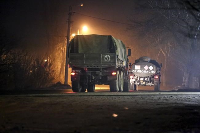 Military trucks move down a street outside Donetsk, the territory controlled by pro-Russian militants, eastern Ukraine, late Tuesday, Feb. 22, 2022. Russian President Vladimir Putin has raised the stakes in the Ukraine standoff by recognizing the independence of rebel regions in the country's east. A key question now is whether he will stop at that or try to move deeper into Ukraine. (AP Photo)