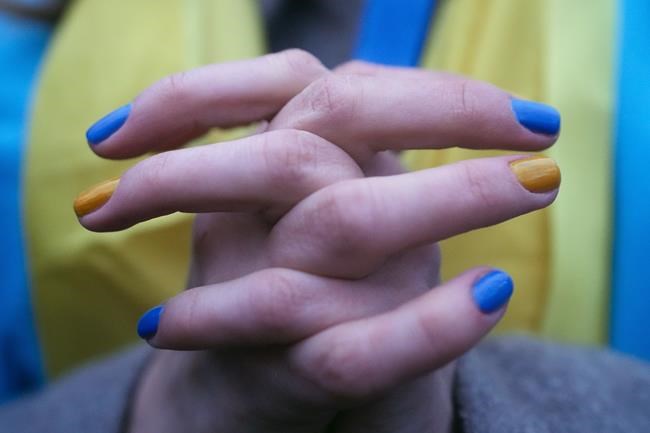 FILE - A woman, her fingernails painted in the colors of the Ukrainian national flag, takes part in a protest against the escalation of the tension between Russia and Ukraine, near the Russian embassy in Berlin, Germany, Tuesday, Feb. 22, 2022. Europe braced for further confrontation Wednesday, Feb. 23, 2022, after tensions over Ukraine escalated dramatically when Russian President Vladimir Putin got the OK to use military force outside his country and the West responded with sanctions. (AP Photo/Markus Schreiber)