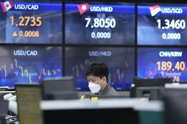 A currency trader watches monitors at the foreign exchange dealing room of the KEB Hana Bank headquarters in Seoul, South Korea, Thursday, Feb. 24, 2022. Asian stock markets followed Wall Street lower Thursday as anxiety about a possible Russian invasion of Ukraine rose. (AP Photo/Ahn Young-joon)