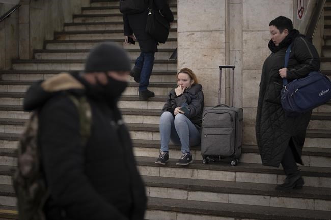People walk in a subway to get a train as they leave the city of Kyiv, Ukraine, Thursday, Feb. 24, 2022. Russian President Vladimir Putin on Thursday announced a military operation in Ukraine and warned other countries that any attempt to interfere with the Russian action would lead to